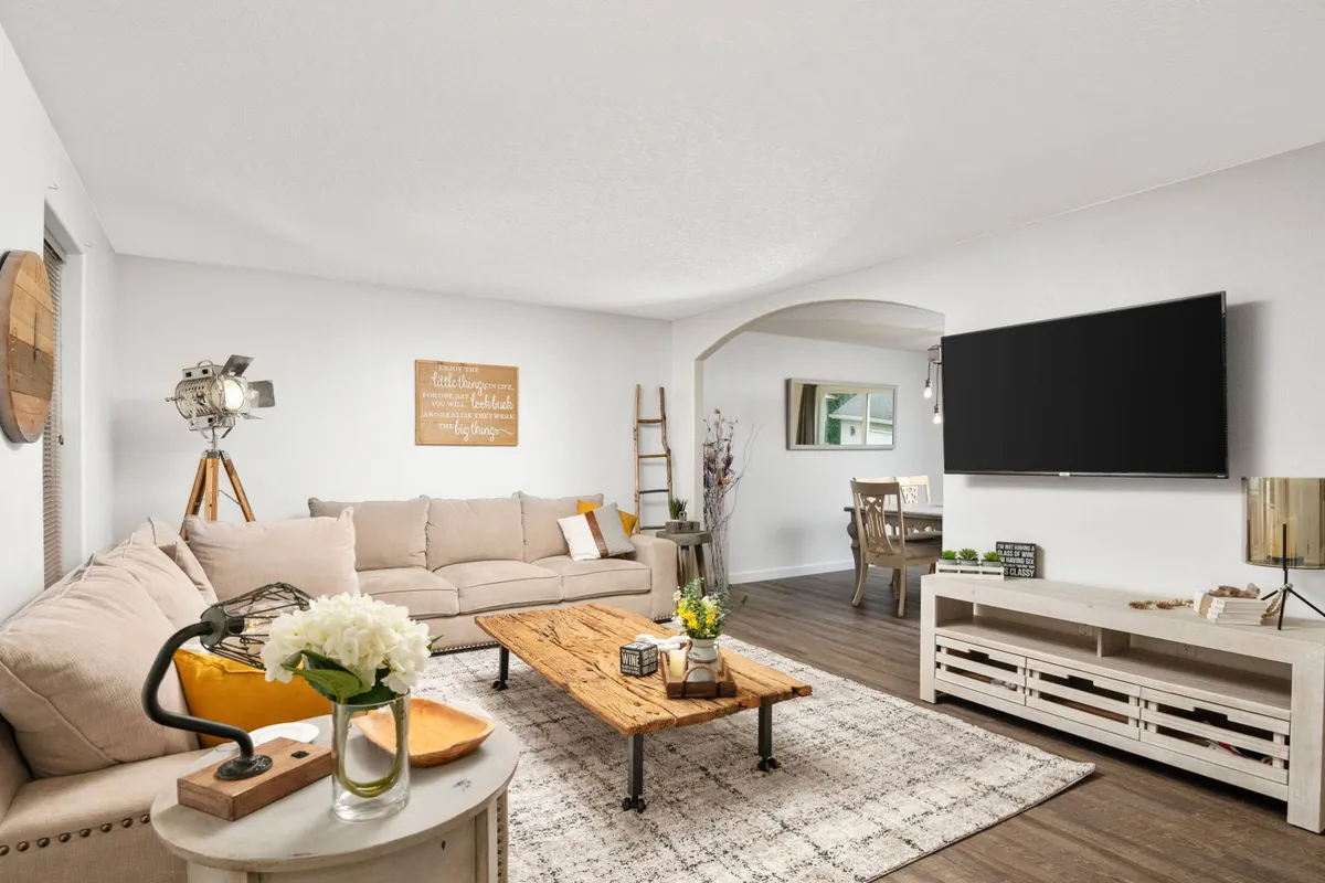 A comfortable living room with plush sofa seating, a sleek coffee table, TV, and tasteful wall art. The space is arranged for relaxation and group gatherings, offering a welcoming, cozy atmosphere for both casual hangouts and special moments.
