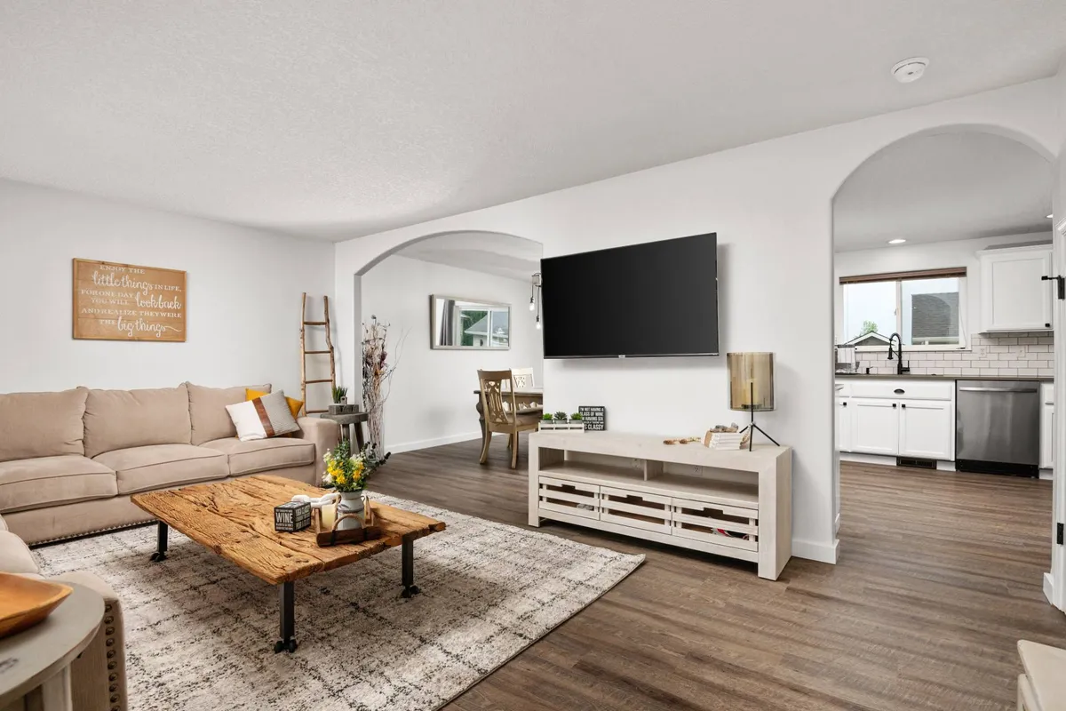 The image showcases a spacious, inviting living area featuring a comfortable sofa, stylish coffee table, and a large TV, seamlessly connected to a modern dining space—perfect for gatherings. The setting exudes warmth and coziness, ideal for movie nights, family fun, and relaxed entertaining.